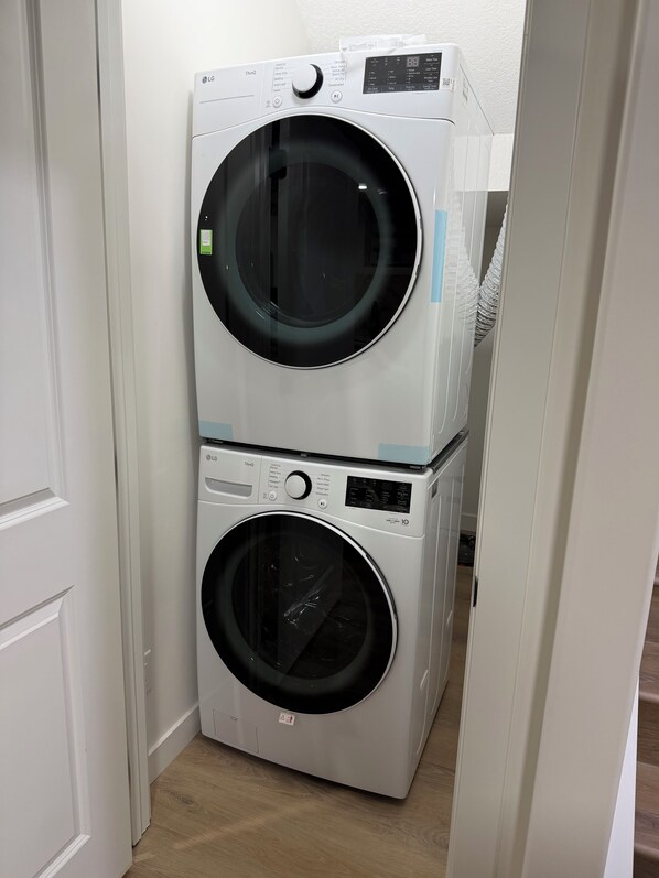 A stacked washer and dryer unit in a narrow hallway.