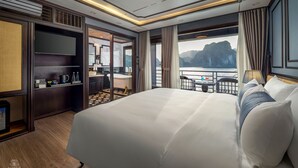 A luxurious hotel room with a large bed, a bathroom with a bathtub, and a view of the sea. - Aime'e Luxury Cruise (Bai Chay)