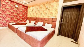 A hotel room with two beds, a clock on the wall, and a door. - Premium Hotel Sipra near Mahakal Temple  (Ujjain)