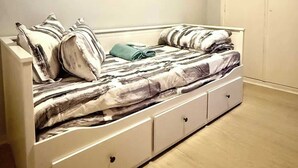 A bedroom with a bed, a wardrobe, and a door.