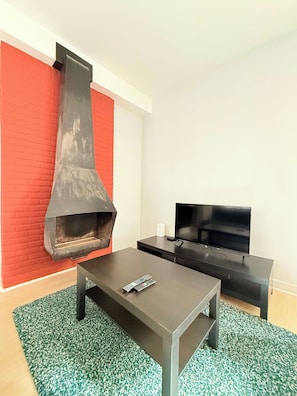 A modern living room with a fireplace, a flat-screen TV, and a coffee table. - Stay in the Heart of Brussels – Steps from Grand Place & Manneken Pis (Brussels)