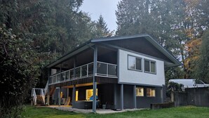 Una casa moderna de dos pisos amb un balcó i una zona exterior coberta.
