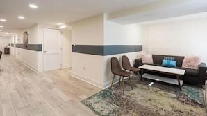A modern living room with a sofa, chairs, a coffee table, and a patterned rug. - Charming townhome ground floor/basement unit (Washington)