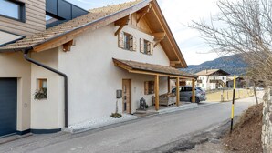 A two-story house with a sloped roof, wooden beams, and a covered porch. - Apartment 'Panorama Val Di Non' with Mountain View, Wi-Fi, and Air Conditioning (Unsere Liebe Frau im Walde-St. Felix)