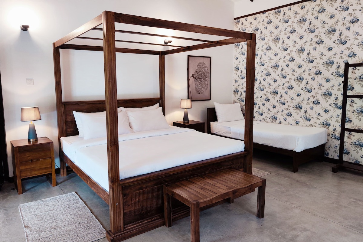 A four-poster bed with a wooden frame, two bedside tables, and a bench.