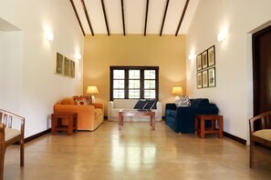 Una sala de estar amplia con tres sofás, una mesa de centro y un ventanal grande.
