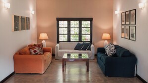 Un salon avec deux canapés, une table basse et des lampes fixées au mur.