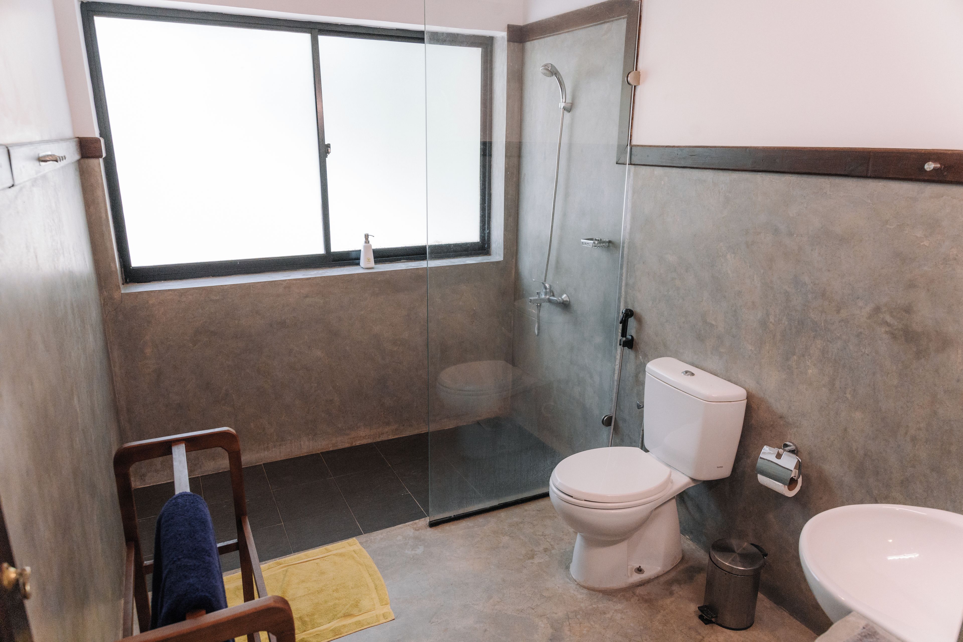 A bathroom with a toilet, bidet, and shower.