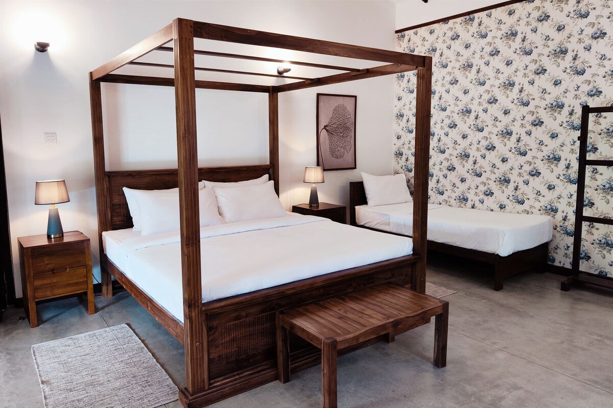 A four-poster bed with a wooden frame, two bedside tables, and a bench.
