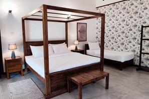 A four-poster bed with a wooden frame, two bedside tables, and a bench.
