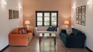 Una sala de estar con dos sofás, una mesa de centro y lámparas de pared.