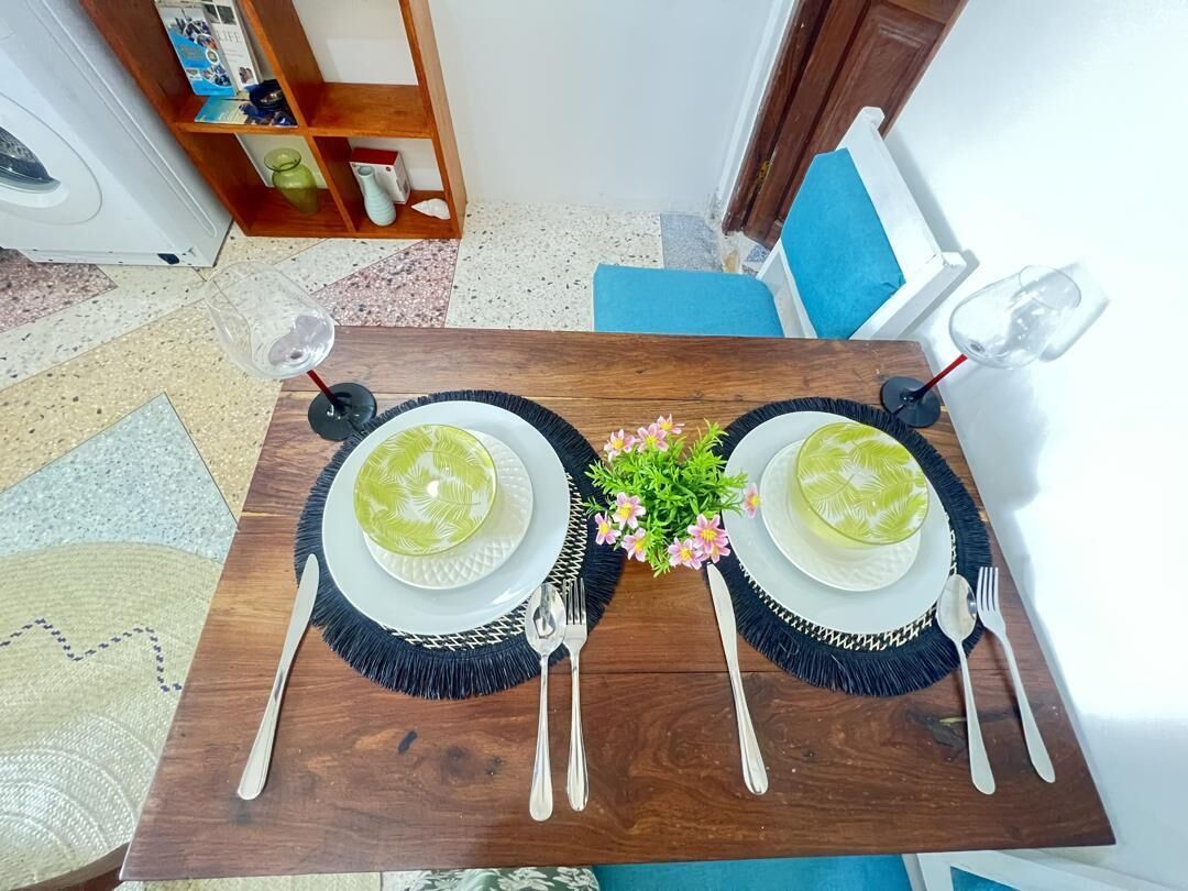 A dining table set with plates, cutlery, and a centerpiece.