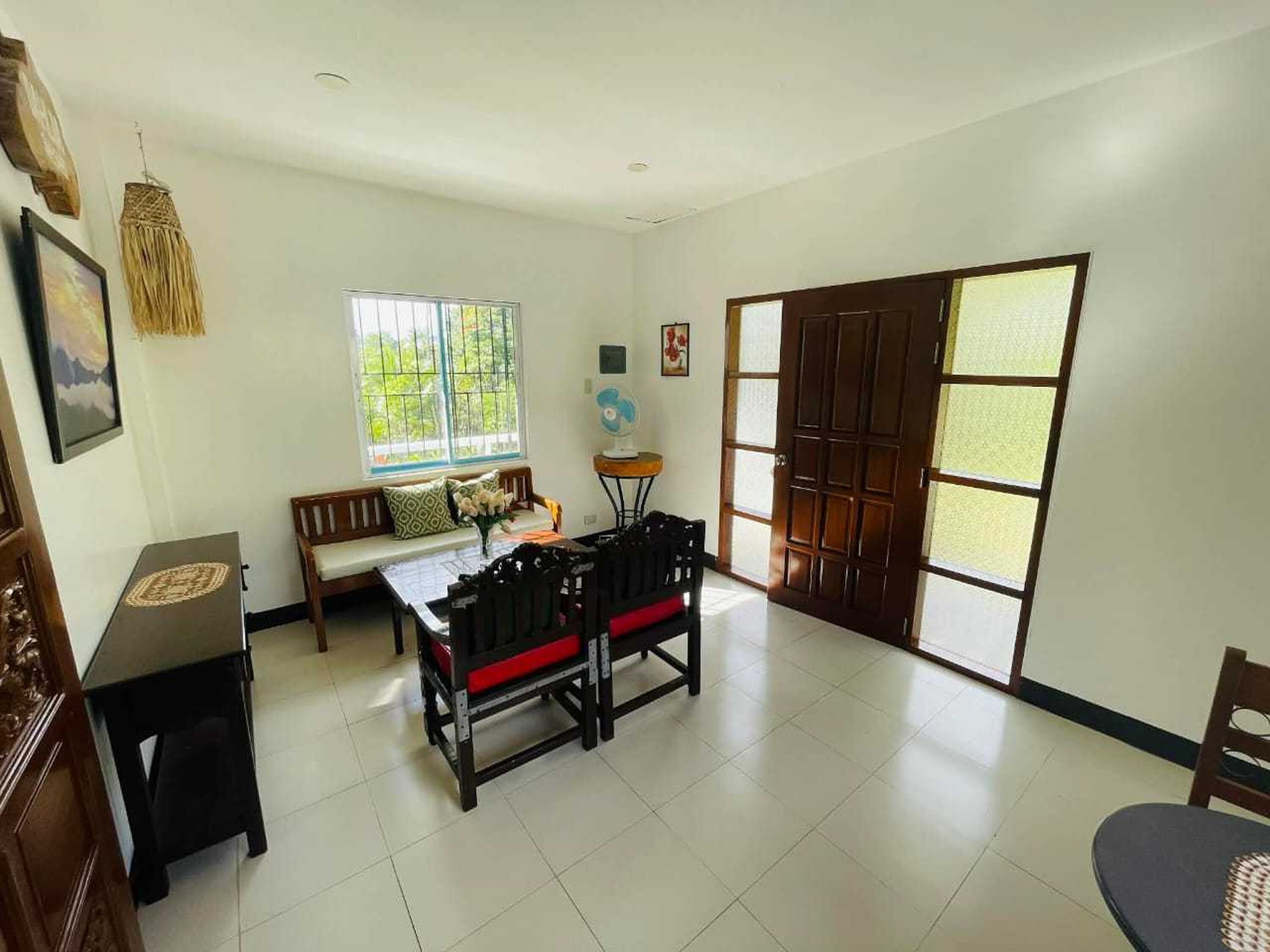A spacious room with a dining table, a sofa, and a large window with a view.