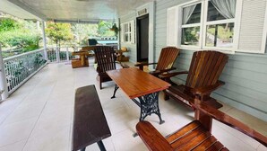 A covered patio with wooden furniture, including a bench, chairs, and a table. - 1193 Pinehall Farm Rizal (Antipolo)