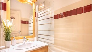 A modern bathroom with a white sink, wooden vanity, and a glass shower enclosure. - Apt. in Chamrousse near supermarket (Chamrousse)