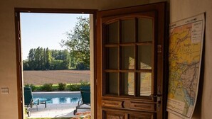 An open door leading to a swimming pool with a garden view. - Holiday home in Pardaillan with private pool (Pardaillan)