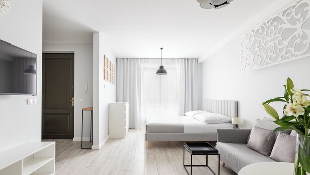 Een moderne slaapkamer met een bed, nachtkastje en een televisie.