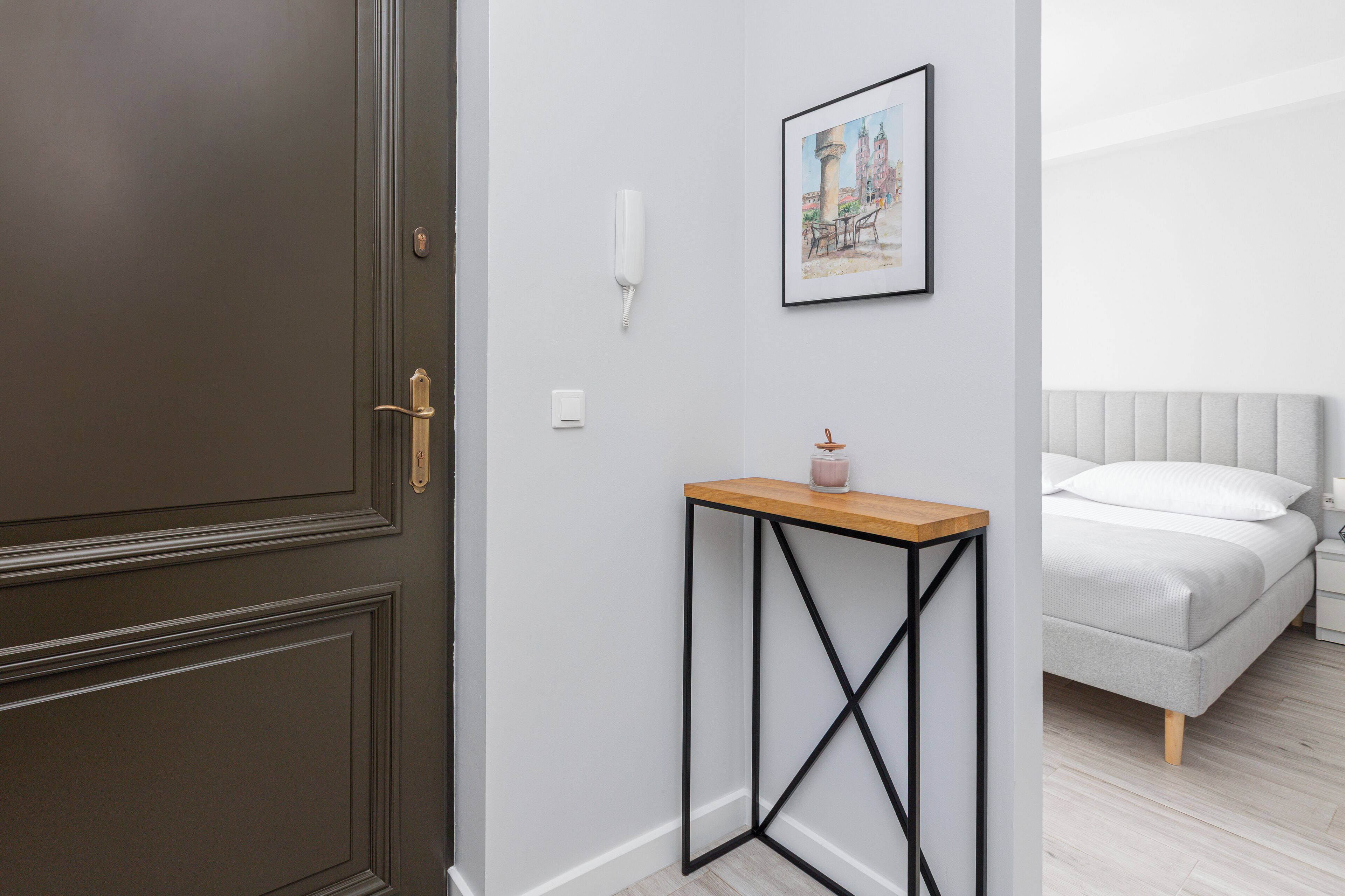A bedroom with a bed, bedside table, and a framed picture on the wall.