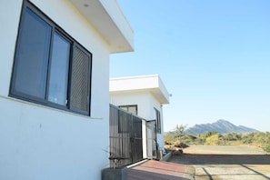 A modern building with a white exterior, large windows, and a black gate.