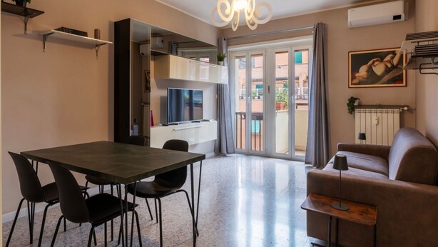 Una sala de estar moderna con una mesa de comedor, sofá y televisor.