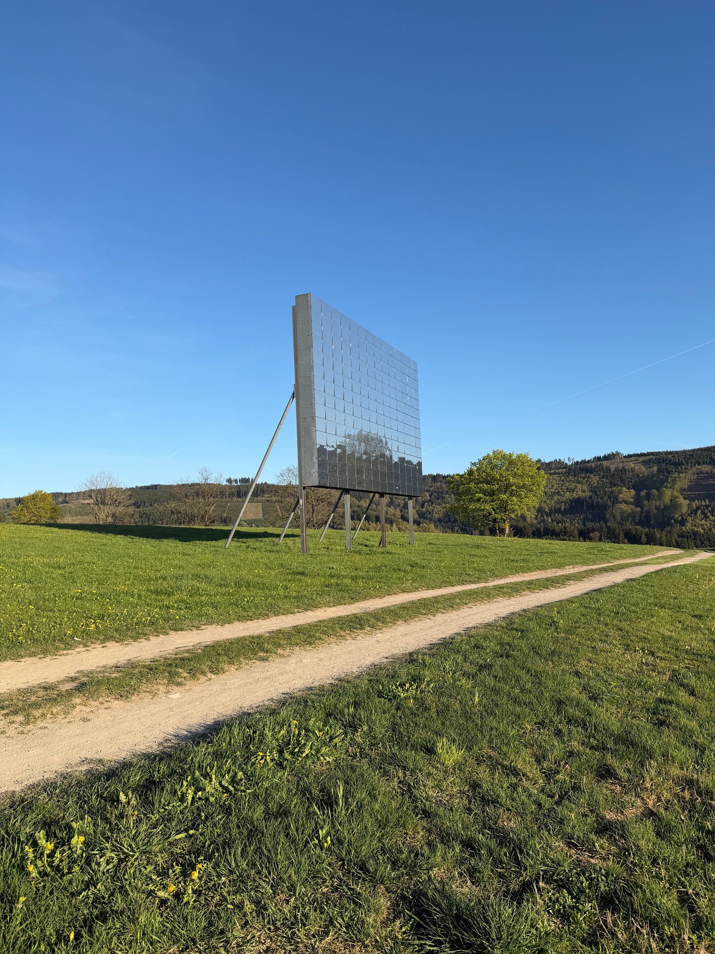 A large, modern building with a reflective glass facade in a rural setting.