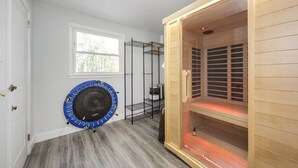 A room with a wooden cabinet, a circular blue object, and a metal shelving unit. - Modern Huntersville Oasis w Sauna, Fire Pit, Screened Patio & Fenced Yard For Pets! + 15% Off Stay! (Huntersville)