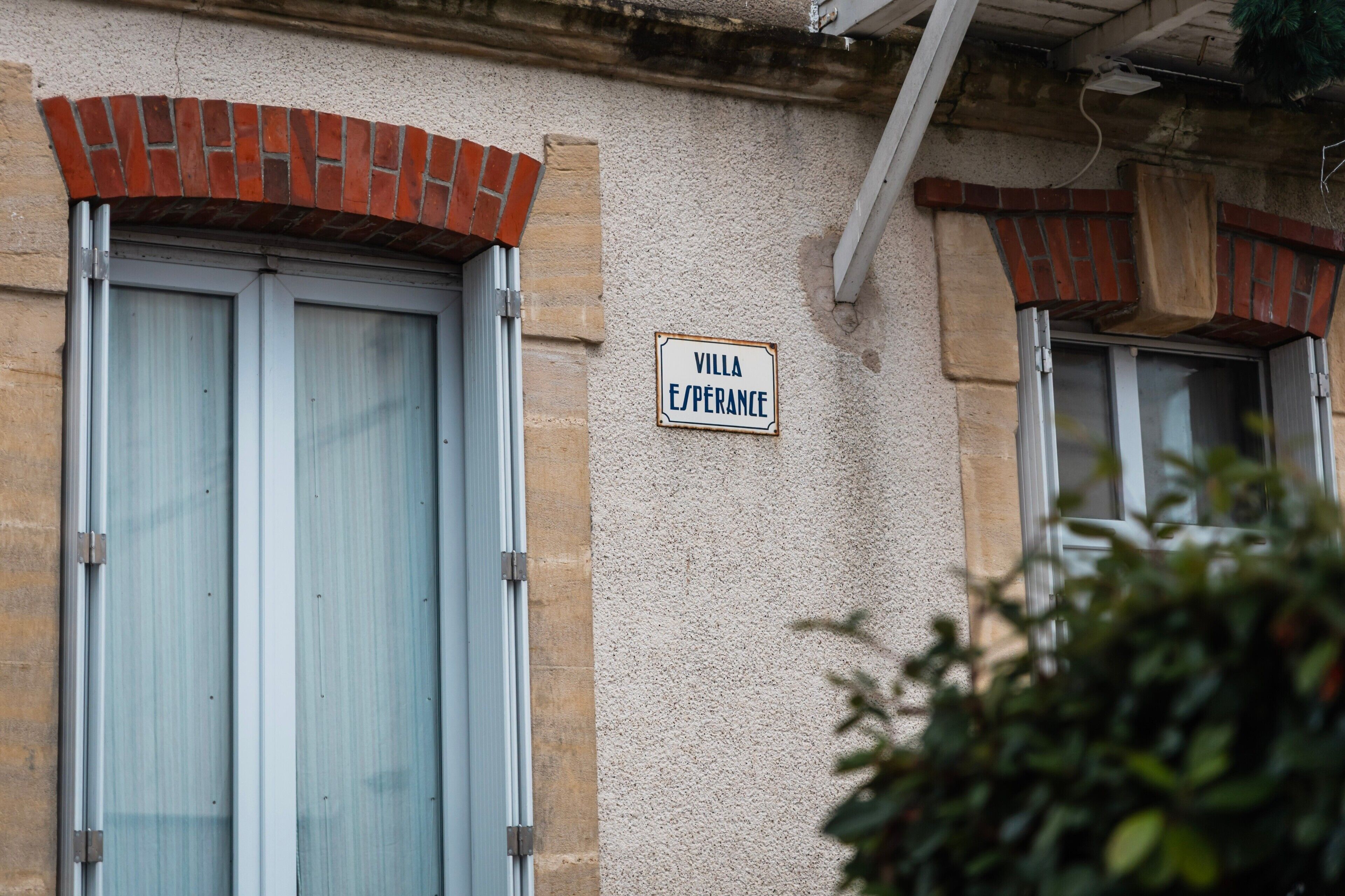 A building with a sign reading 'VILLA ESPERANCE' and large windows with shutters.