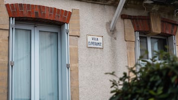 A building with a sign reading 'VILLA ESPERANCE' and large windows with shutters.