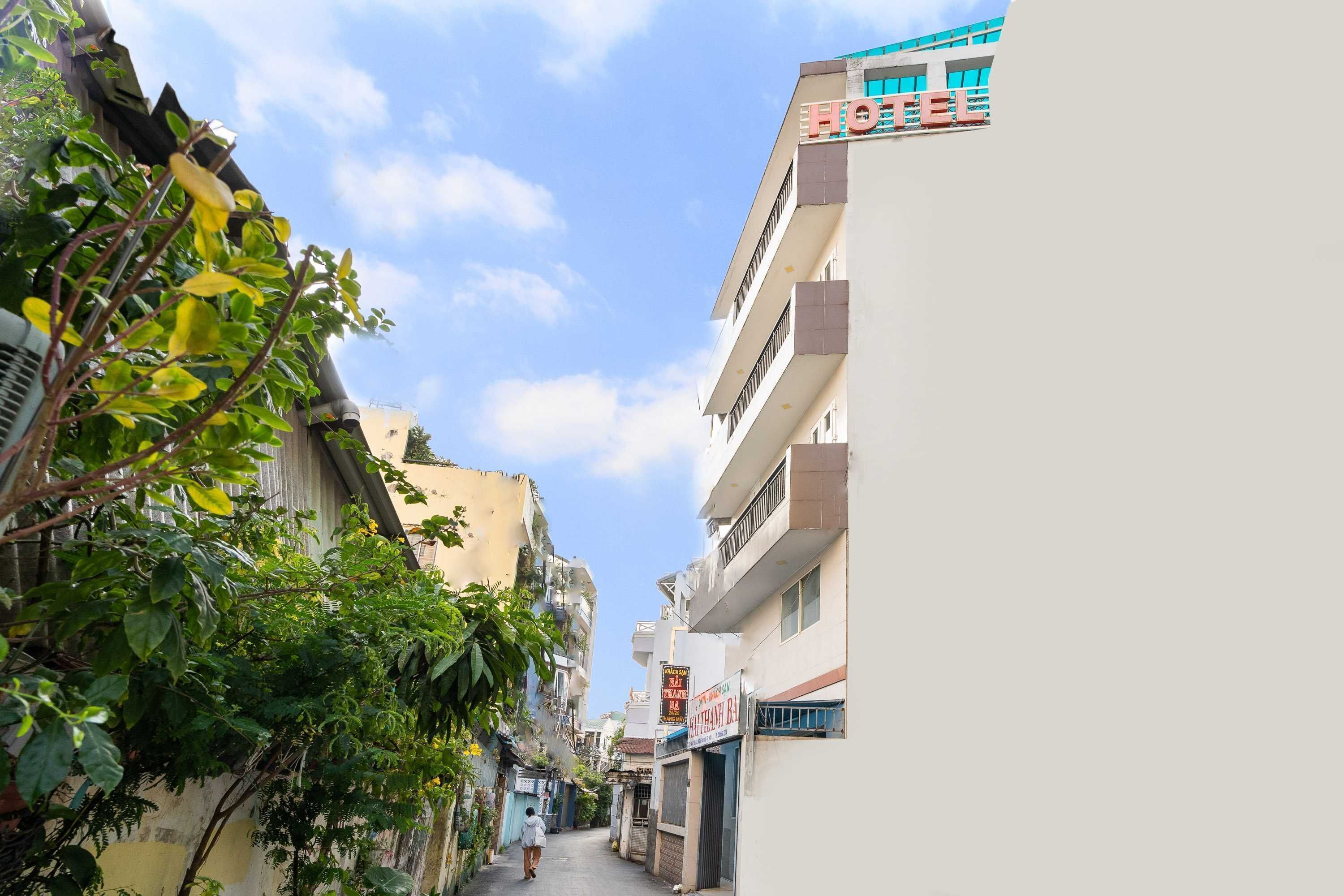 A narrow street with a hotel on the right and a building with a sign that reads "HOTEL".