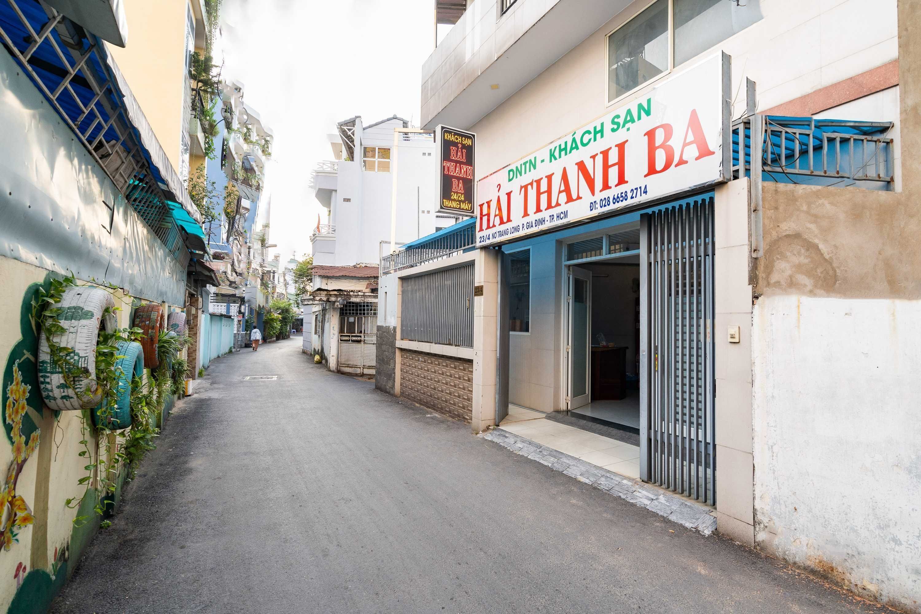 En smal gade med bygninger på begge sider, herunder en butik med skilt på vietnamesisk.