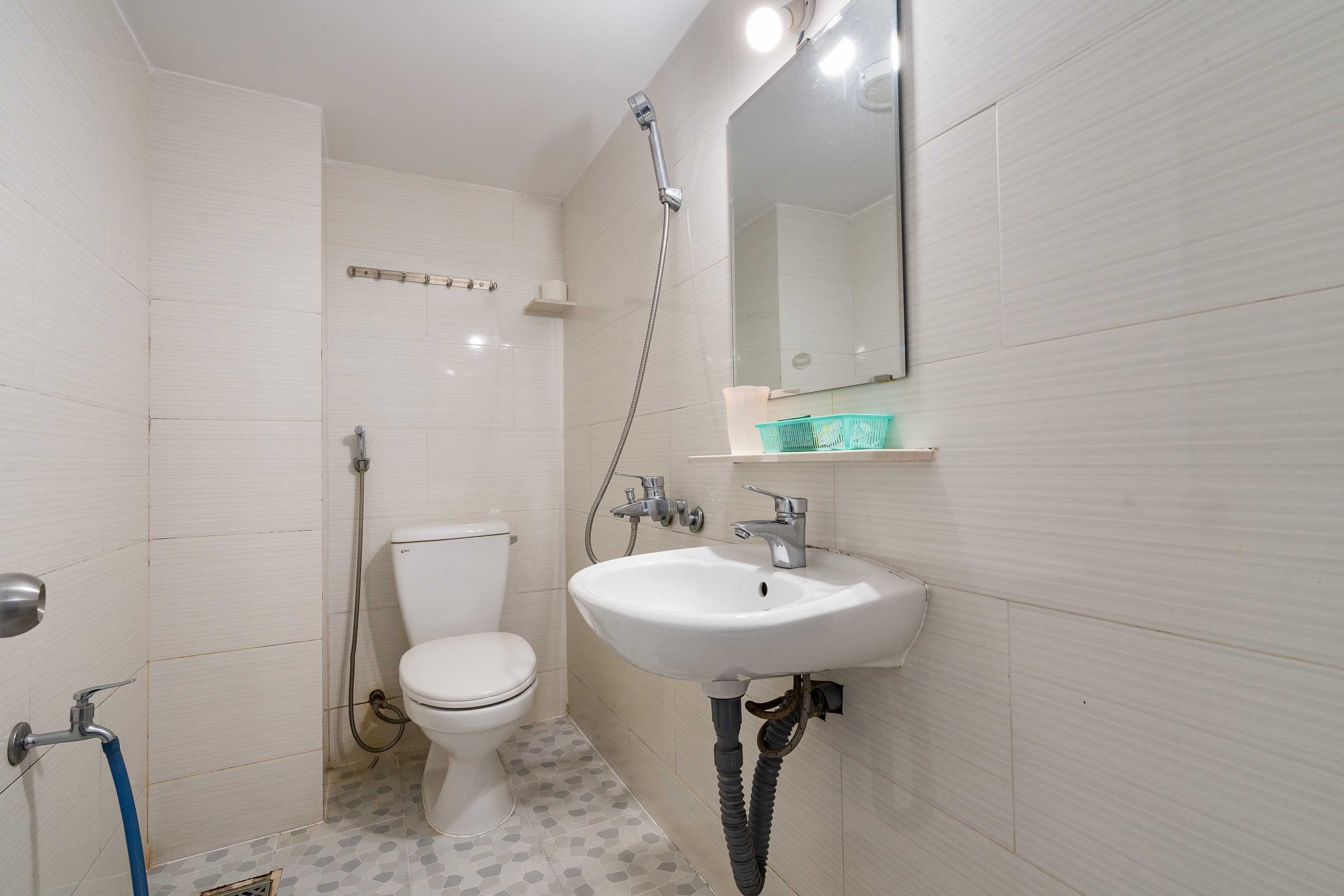 A small bathroom with a toilet, a sink, and a shower.