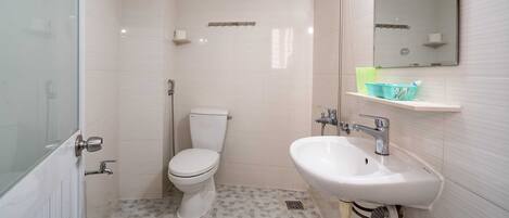 Une salle de bain avec des toilettes, un lavabo et un miroir.