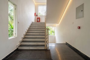 Una escalera con extintor y detector de incendios en la pared.