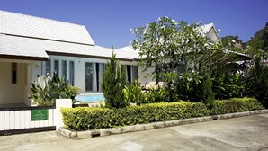 A modern building with a white facade, large windows, and a swimming pool in the front. - Baan Gecko (Krabi)