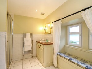 A bathroom with a shower, a sink, a toilet, and a window with a view.