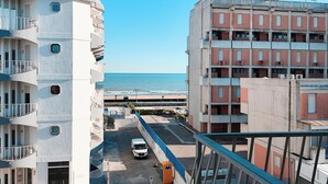 Um edifício com várias andares e varandas com vista para a praia.
