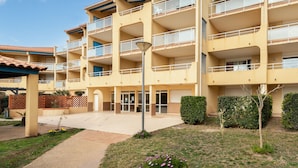 Hotel de diversos pisos amb balcons, entrada central i una petita zona de jardí.