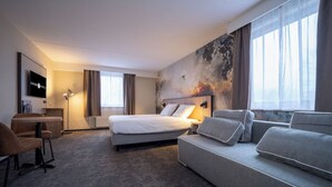 A hotel room with a bed, a sofa, a desk, and a TV. - Charming Stay in Arcen | Single Unit | Near Roobeekweg Park (Arcen)