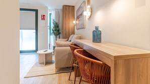 Una cuina moderna amb taulell de fusta, tamborets i il·luminació penjant.