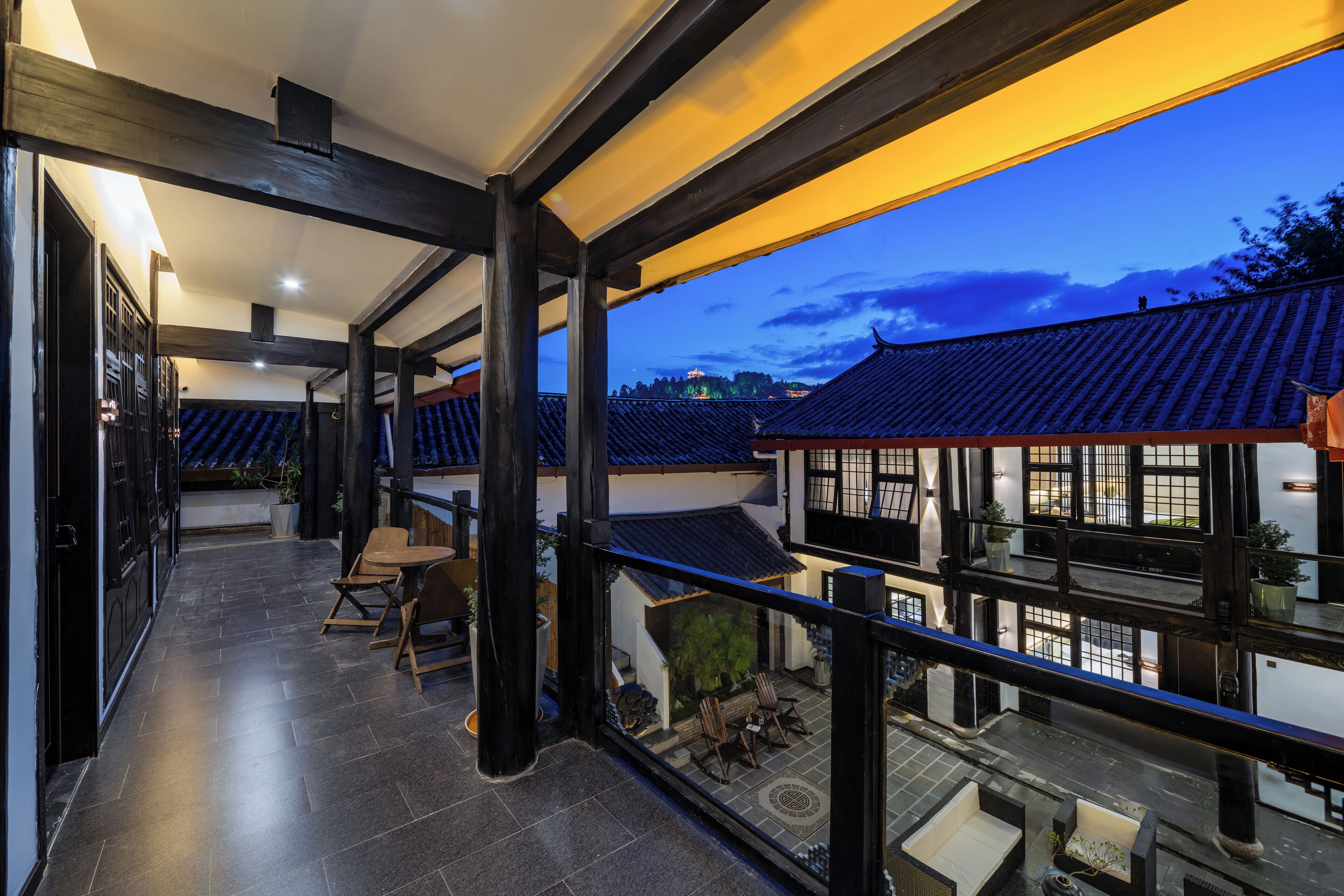 A modern interior with a balcony overlooking traditional architecture.