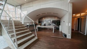 A modern interior with a curved ceiling, a staircase, and a central seating area. - At home in the location with pool in beautiful surroundings (Graßnitzberg)
