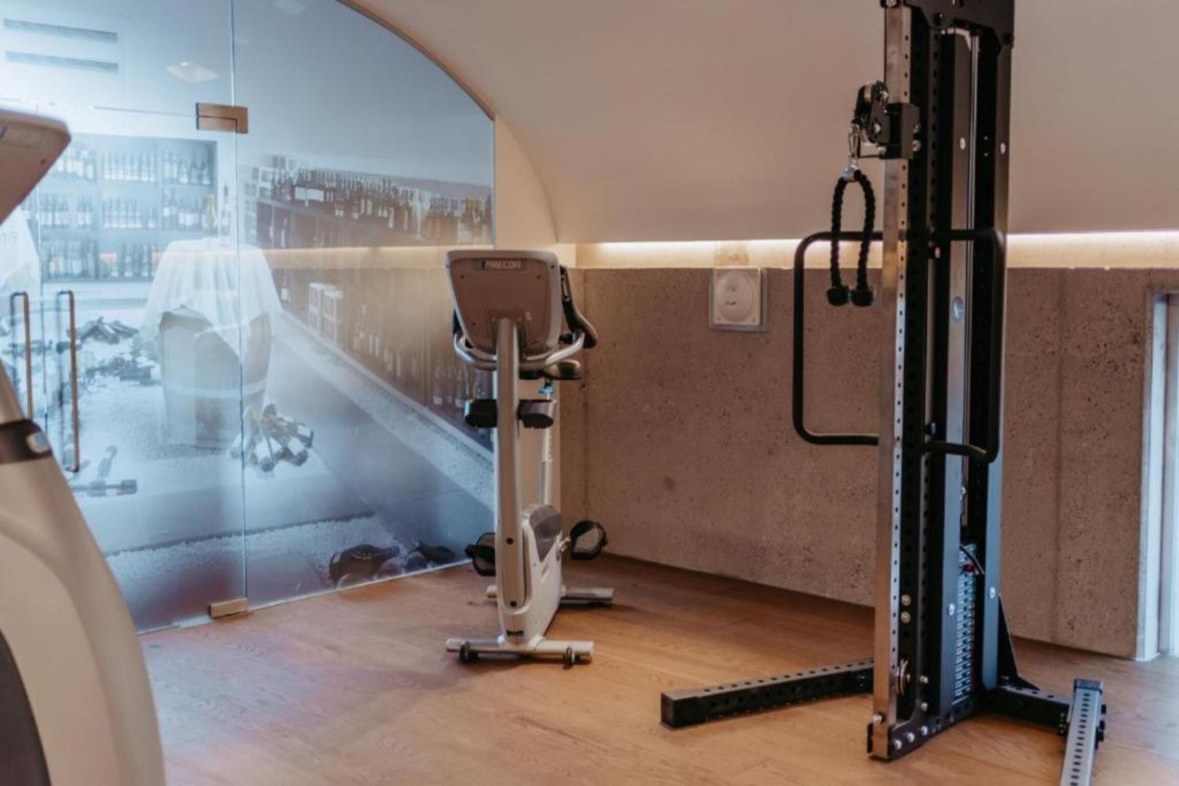 Un gimnasio moderno con una bicicleta estática, una cinta de correr y una máquina de pesas.