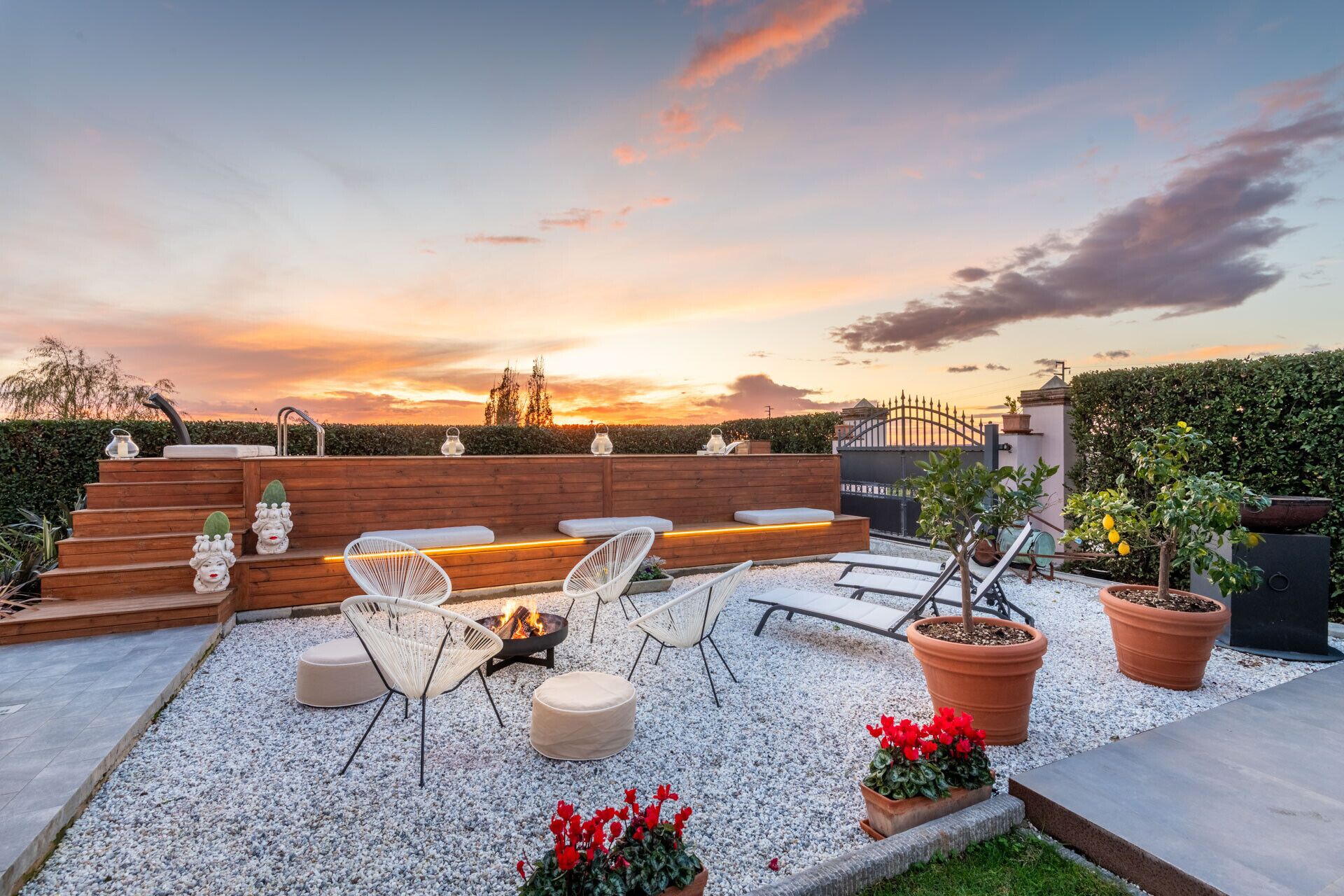 Une terrasse sur le toit, aménagée avec des sièges, un foyer et des plantes en pot.
