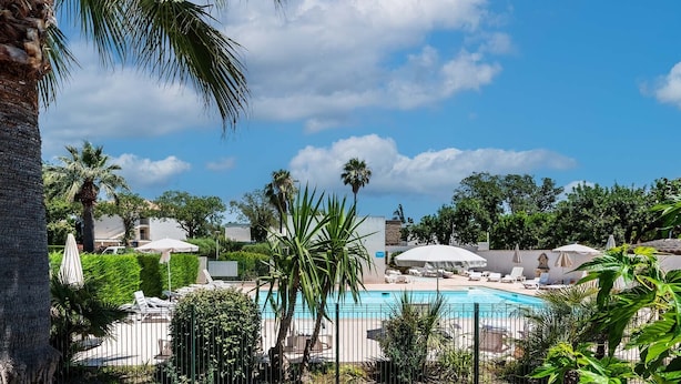 A pool area with lounge chairs and umbrellas, surrounded by palm trees and greenery. - nice Apt for 6 pers near the Marina (Mandelieu-la-Napoule)
