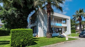 A modern two-story building with a sign indicating it is a hotel. - nice Apt for 6 pers near the Marina (Mandelieu-la-Napoule)