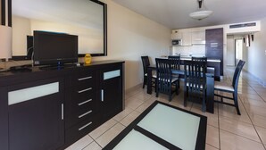 Cozinha moderna com área de jantar, com TV de tela plana, micro-ondas e mesa de jantar com cadeiras.