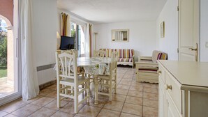 A room with a dining table, chairs, a television, a sofa, and a bed. - Air-conditioned house for 6 people with garden and swimming pool near the lake (Homps)