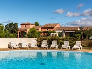 A swimming pool with lounge chairs, a building with a red-tiled roof, and greenery in the background. - South-facing villa for 6 people with a garden and swimming pool (Homps)