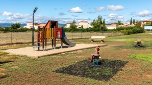 A playground with a slide, swings, and a bench. - Charming villa with garden for 6 pers (Homps)
