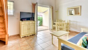 A room with a television, a cabinet, a table, a chair, a bed, and a mirror. - Charming villa with garden for 6 pers (Homps)